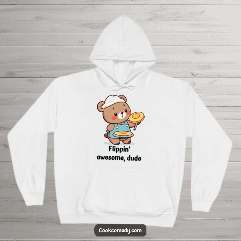 Funny hoodie depicting a busy bear chef in an apron, flipping a pancake, perfect for cozy and humorous mornings.