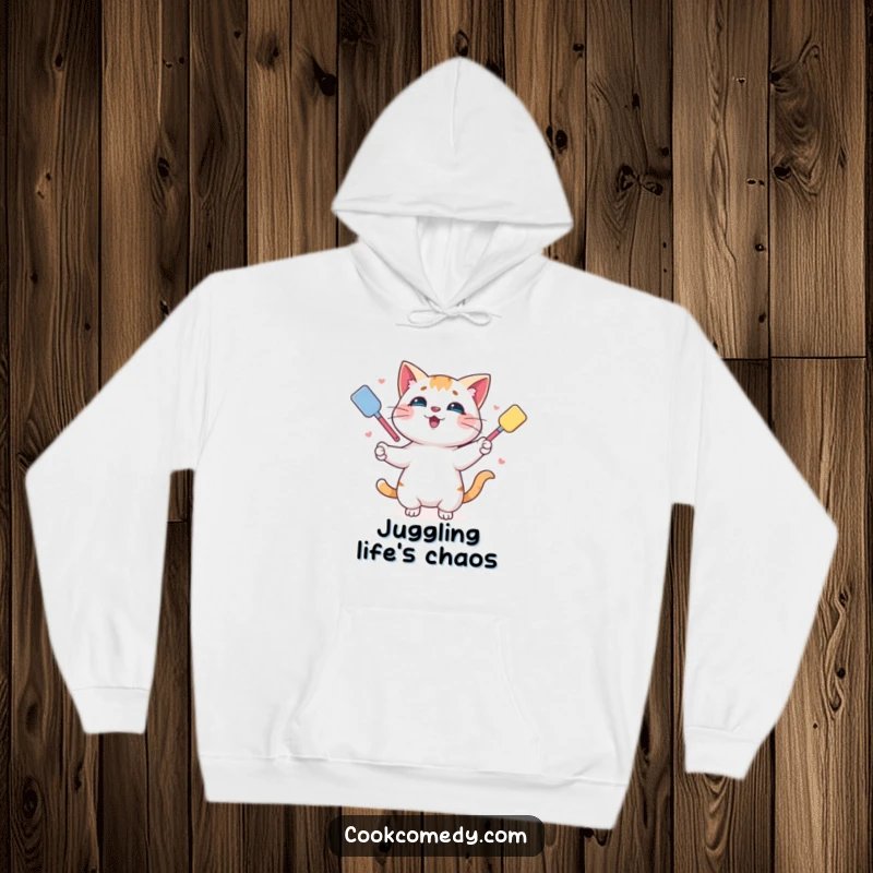 Funny hoodie featuring a playful cat juggling spatulas, designed for cozy days and humorous kitchen vibes.